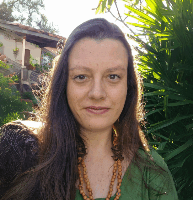 A professional headshot of Juliana Gatti-Rodrigues, an environmental expert and researcher, smiling lightly in an outdoor setting.