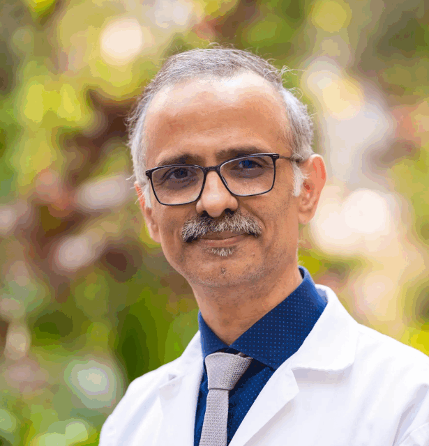 A professional headshot of Zubin Marolia, a homeopathic physician and specialist in integrative oncology from India.